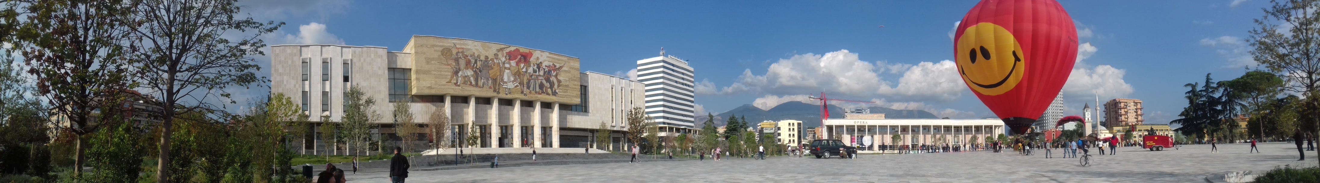Panorama photo from the central square of Tirana. National Museum with the mosaic 'Albania', big baloon with a smiley face at the center of the square.